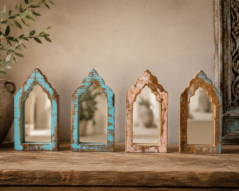 Quatre miroirs arqués en bois recyclé posés sur une tablette