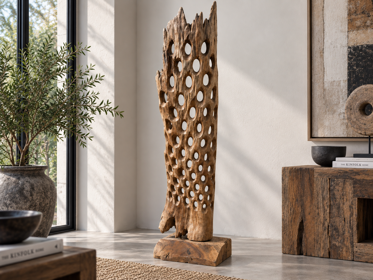 Sculpture colonne ajourée en teck posée au sol dans une entrée