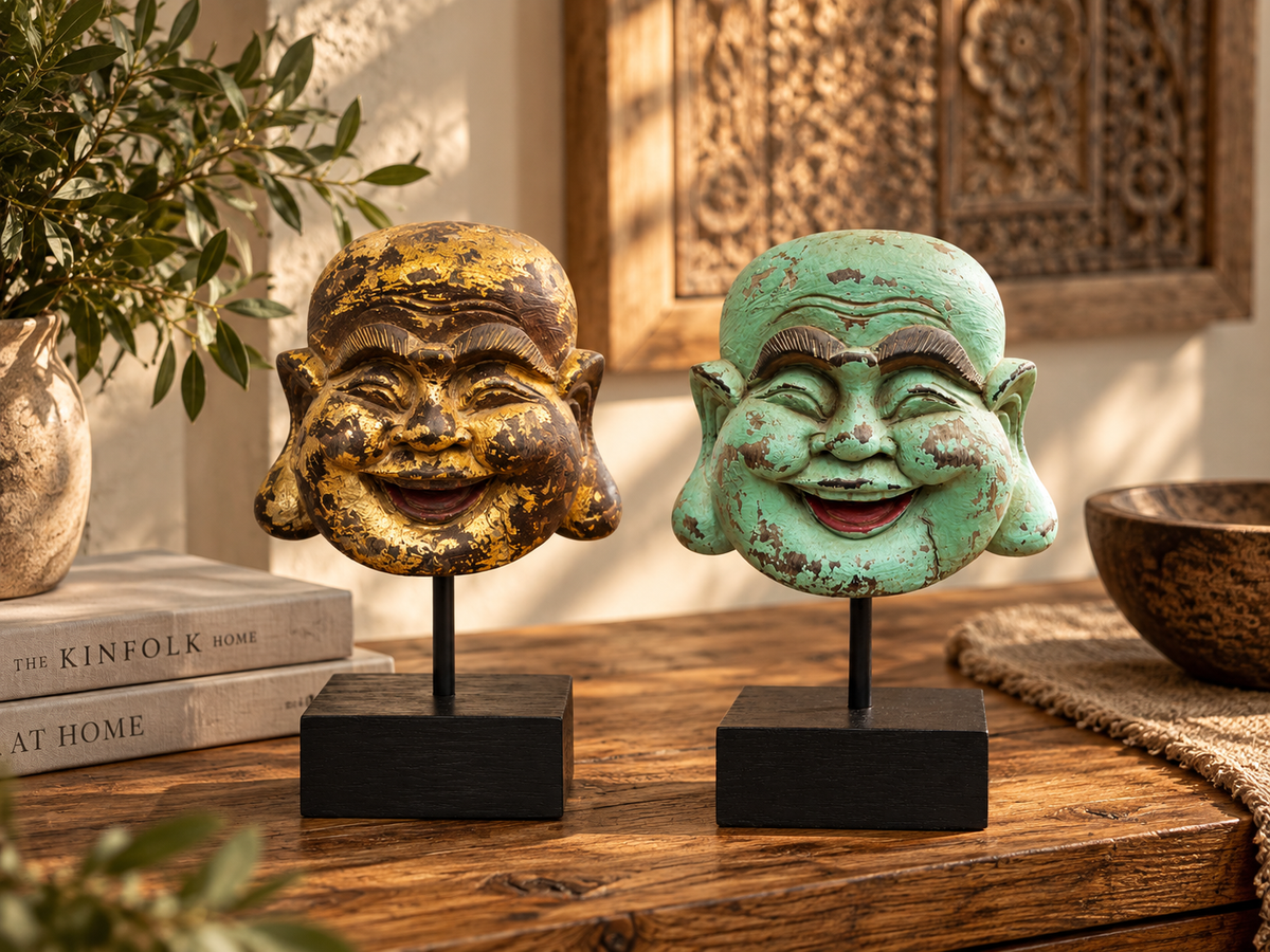 Deux têtes de Bouddha rieur sur socles noirs, l'une dorée et l'autre vert-de-gris