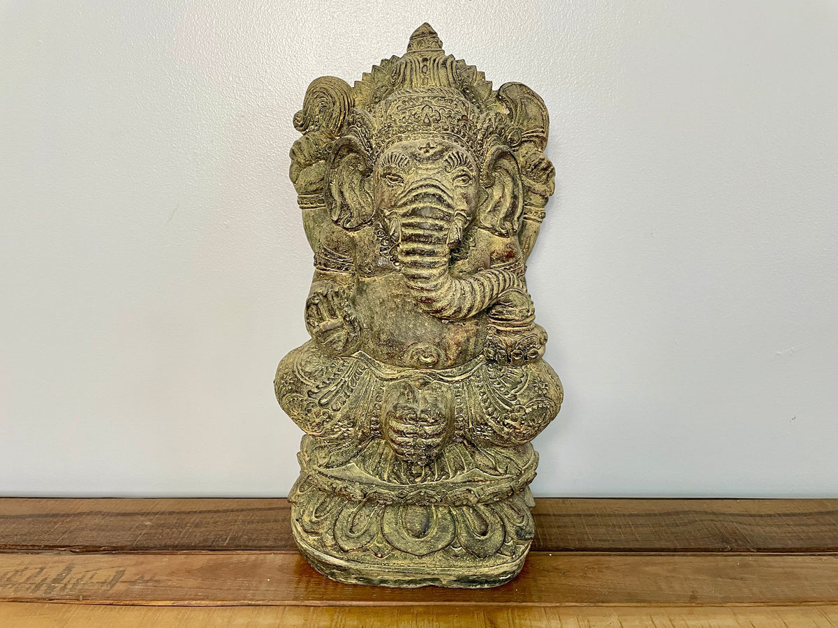 Statue de Ganesh en pierre assise sur un socle en lotus, vue de face