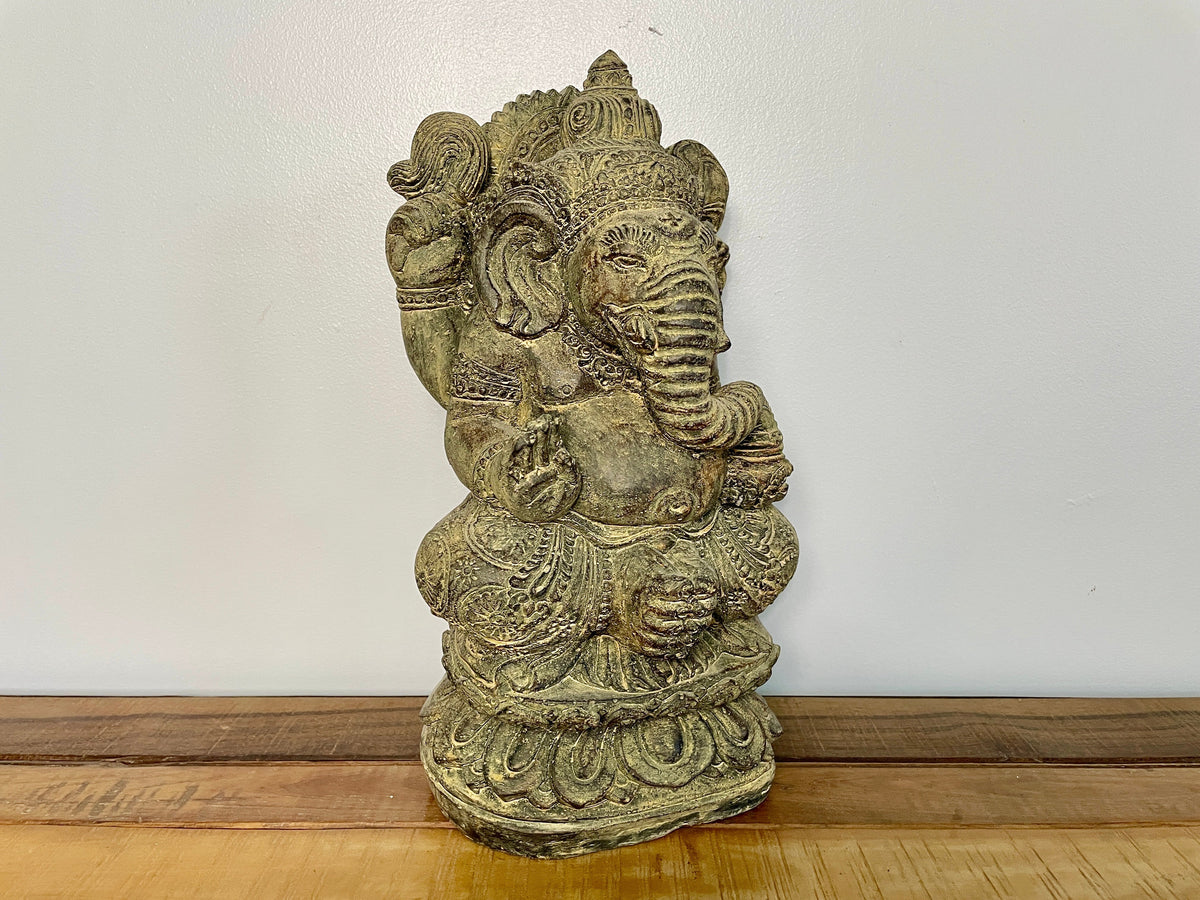 Statue de Ganesh en pierre vue de trois quarts, coiffe et bijoux sculptés