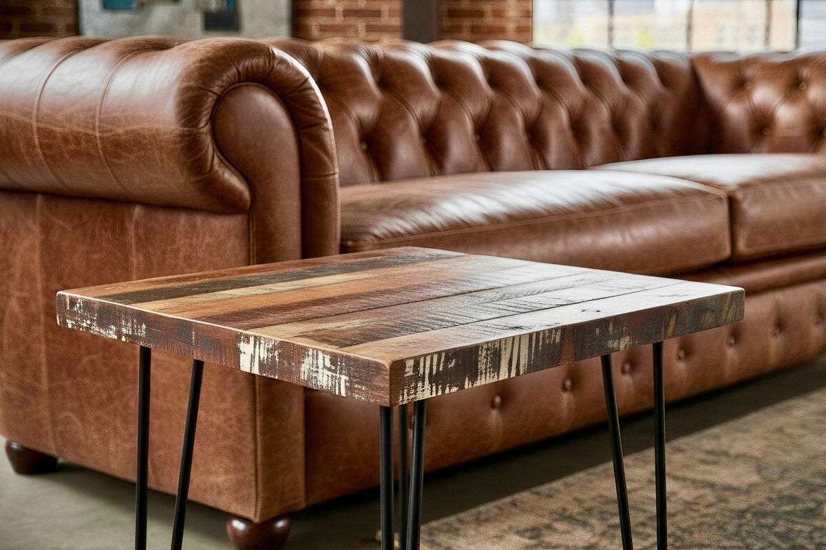 Petite table d'appoint en bois recyclé sur pattes en épingle, à côté d'un canapé Chesterfield en cuir