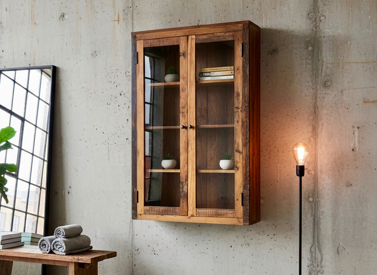 Vitrine murale en bois recyclé accrochée à un mur de béton, avec plante