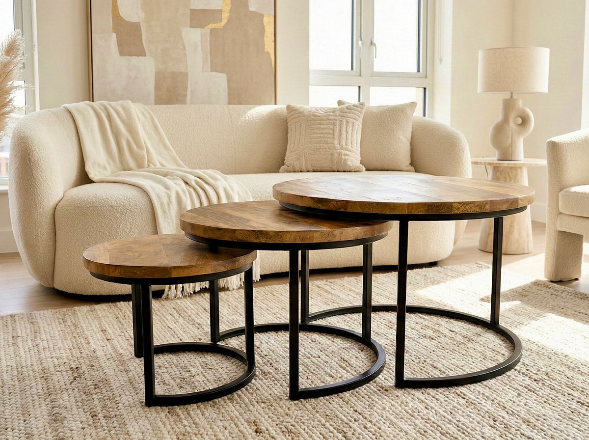 Trois tables gigognes rondes en manguier et métal noir, dans un salon beige