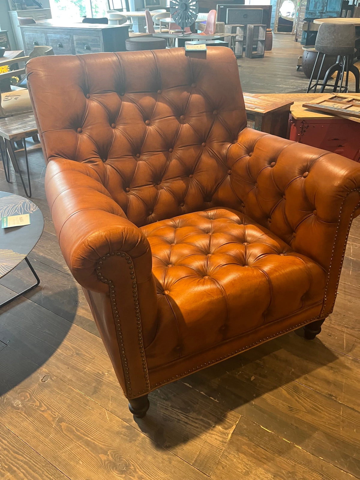 Fauteuil Chesterfield en cuir cognac à dossier haut capitonné, vu de trois quarts