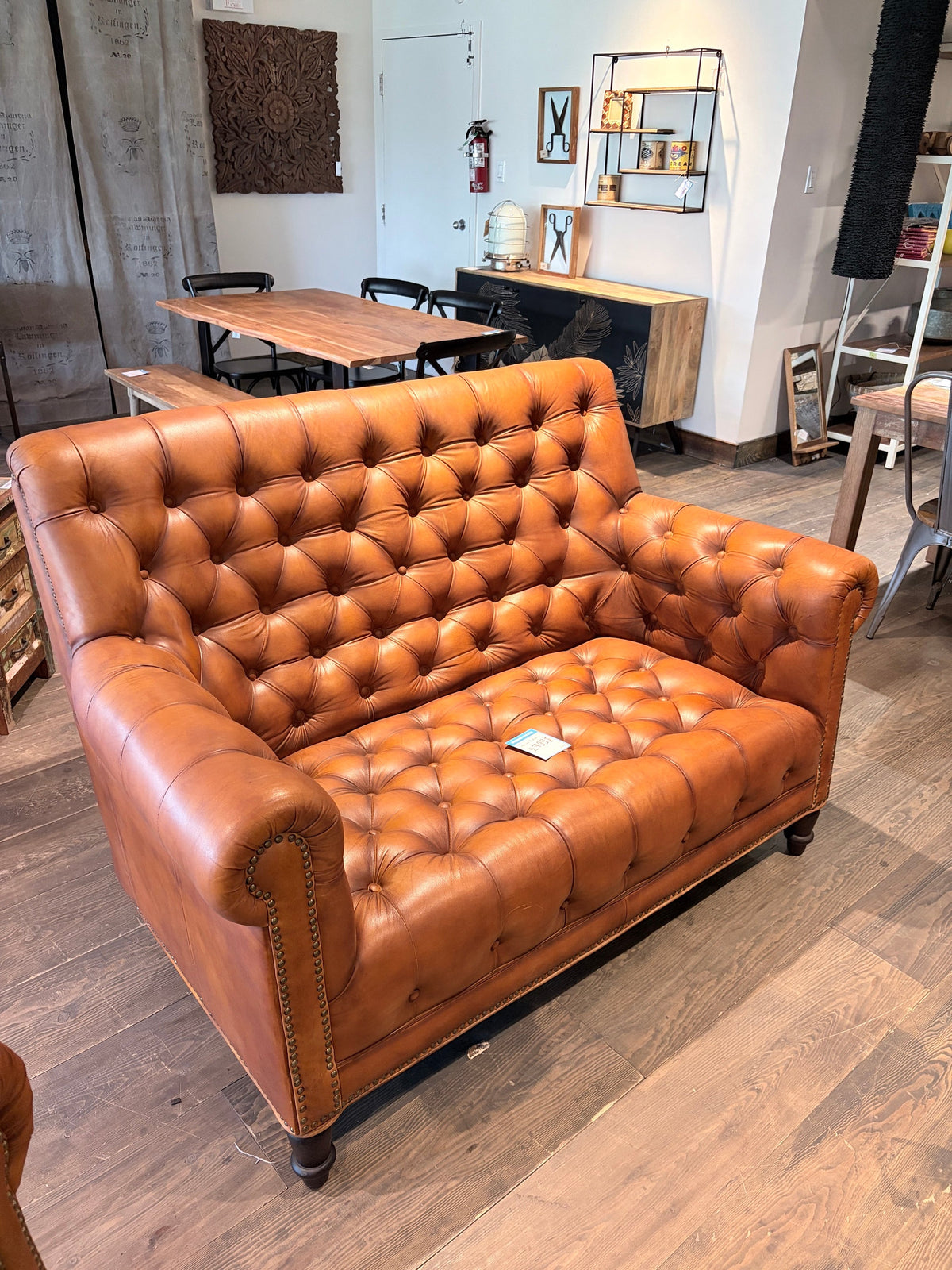 Canapé Chesterfield en cuir cognac vu de côté, accoudoirs roulés