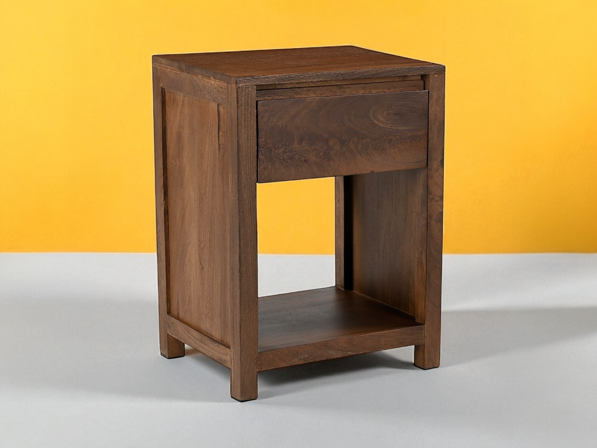 Table de nuit Kona en manguier teinté brun, devant un mur jaune
