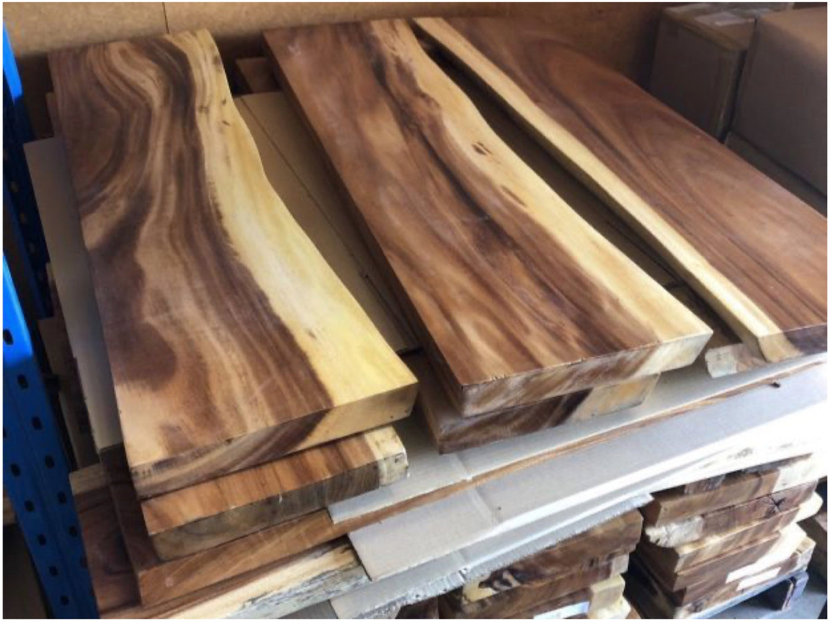 Plateaux de suar empilés à l'atelier, bords naturels visibles