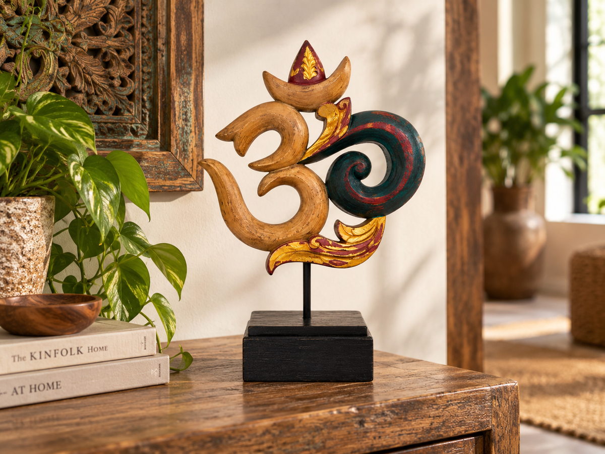 Sculpture Om en bois sur socle noir posée sur une console, près d'une plante